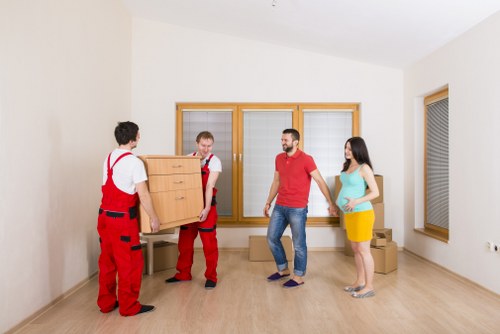 Removal crew handling desks and furniture in a London commercial building