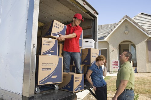 Movers handling boxes and furniture in a London home removal